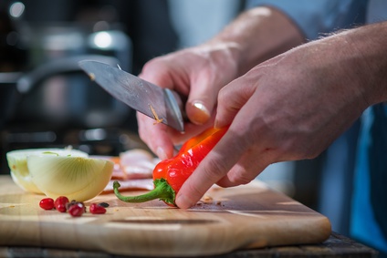 Man cutting red peppers with a knife